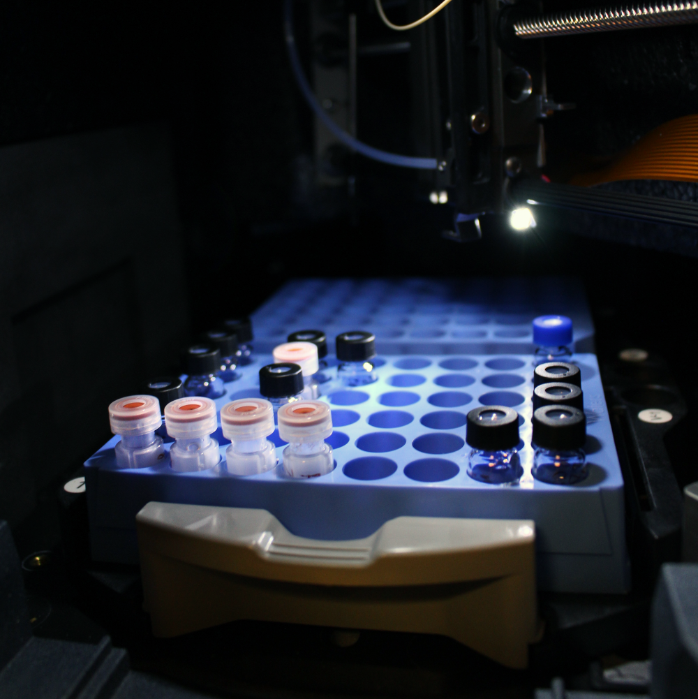 Sample bottles in a container under a light