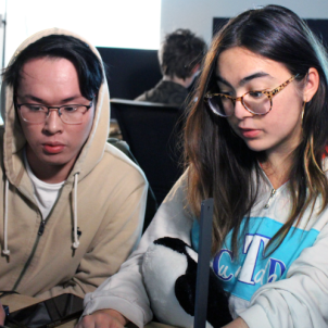 Two people looking at a laptop screen